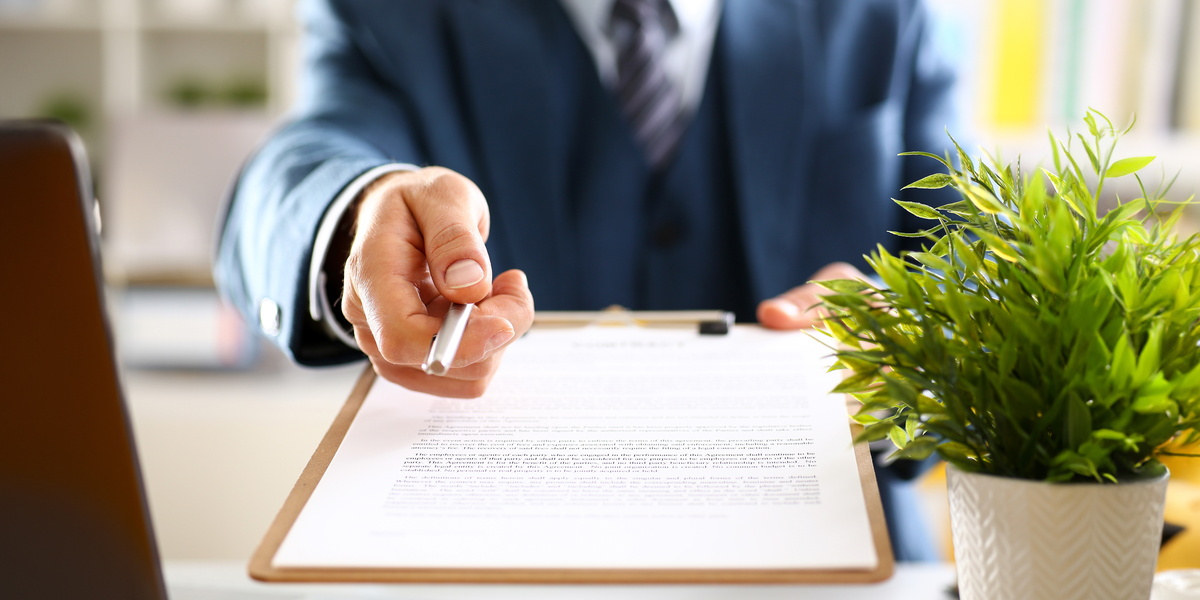 Male arm in suit offer contract form on clipboard